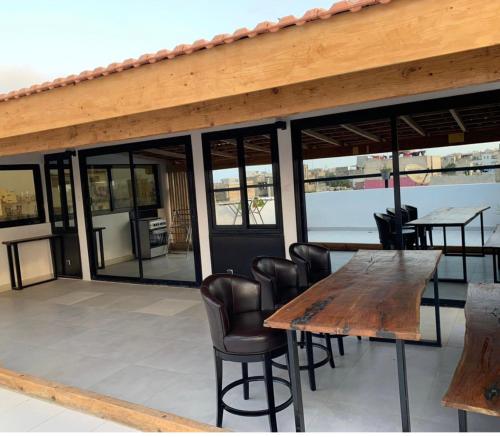 a patio with a wooden table and leather chairs at Résidence Kali in Guediawaye