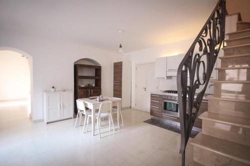 a kitchen with a staircase and a table in a room at Giù nei Sassi in Matera