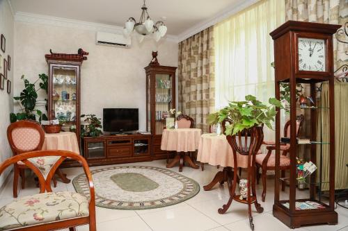 un soggiorno con 2 tavoli e un orologio a pendolo di Vizit Hotel a Ekaterinburg
