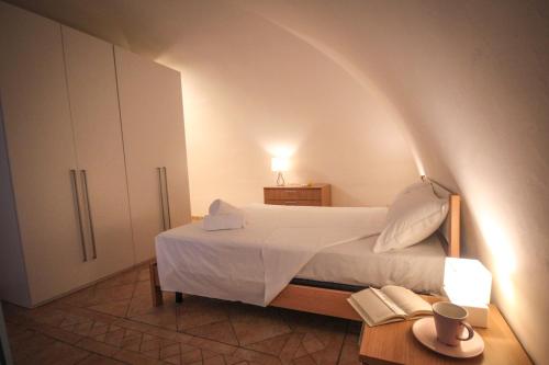 ein Schlafzimmer mit einem Bett, einer Lampe und einem Tisch in der Unterkunft Giù nei Sassi in Matera