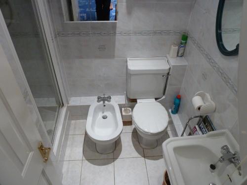 a small bathroom with a toilet and a sink at Spacious in Croxley Green