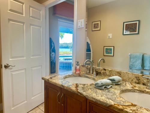 a bathroom with two sinks and a mirror at Guest suite - Waterfront -Pool & Hot tub- Walk to Beach in Clearwater Beach