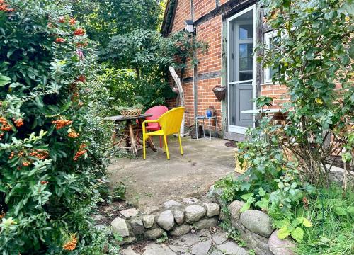 a patio with a table and chairs in a garden at Mecklenbü mit Teich, Kamin, Sauna und Hotpott in Dargun