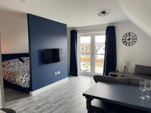 a living room with a bed and a couch and a table at Lochside Loft - Self Catering Apartment for 2 In a great location for Inverness Airport and both Cabot Highlands & Nairn Golf Courses in Inverness