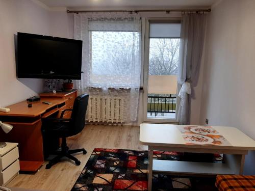 una oficina con escritorio, ordenador y ventana en Apartament Laurka, en Kamienna Góra