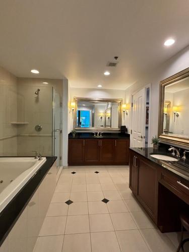 a large bathroom with a tub and a sink at Newly Renovated Panorama Vista 1-BR, 2-BA Suite with Full Kitchen and Private Balcony, Corner Unit in Las Vegas