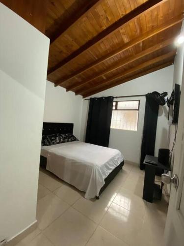 a bedroom with a bed and a wooden ceiling at Apartamento cómodo y agradable in Medellín