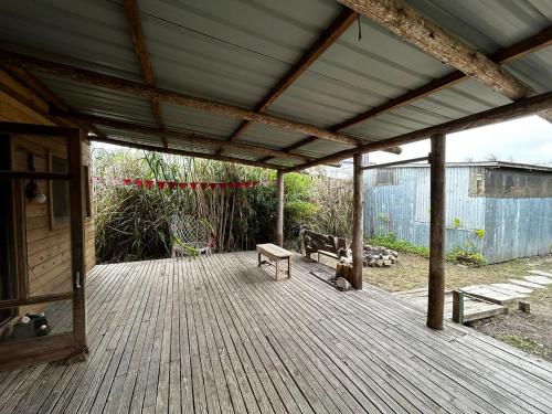 um deque de madeira com dois bancos e uma mesa em Hippie Home em Balneario Buenos Aires