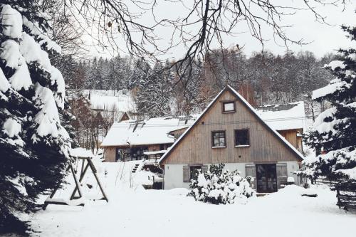 a house is covered in snow with trees at Lavendowo in Piechowice