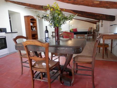 une salle à manger avec une table avec un vase de fleurs dans l'établissement Le grenier du Vissou, à Cabrières