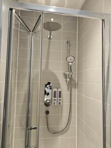 a shower in a bathroom with a glass door at Town center modern apartment 10 in Ipswich