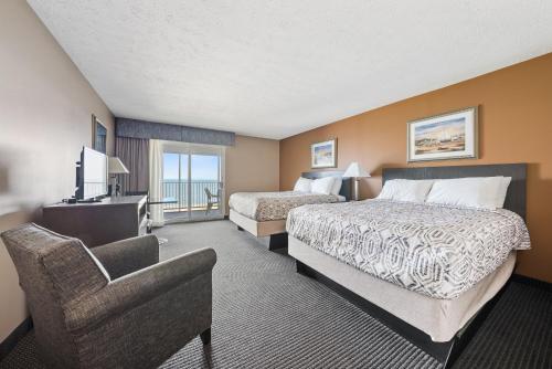 a hotel room with two beds and a chair and a television at Bayshore Resort at Put-in-Bay in Put-in-Bay