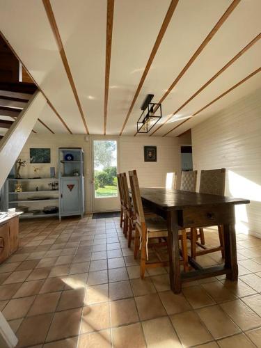 une salle à manger avec une table et des chaises dans une cuisine dans l'établissement Maison familiale en bois avec piscine, proche du bassin, à Gujan-Mestras