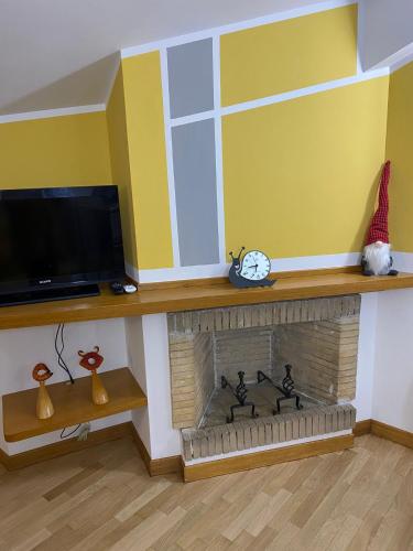 a living room with a fireplace and a tv at La La Home in Avezzano