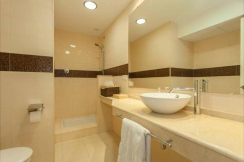 een badkamer met een wastafel, een toilet en een spiegel bij Plaza Madrid Ha Apartment in Cádiz
