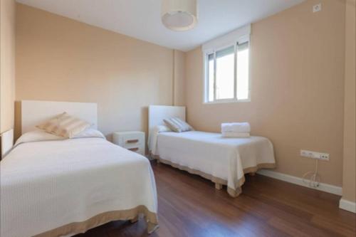una camera con due letti e una finestra di Plaza Madrid Ha Apartment a Cadice