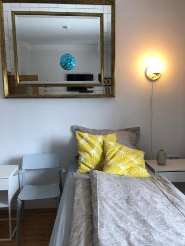 a bedroom with a bed with a mirror and a chair at Apartment in Gelb, mit Balkon, Kamin, 50 Schritte zu Radweg, ideal for Long Stay, 4 Singles in Single Rooms in Mainstockheim
