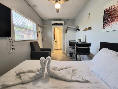 a room with a bed with two swans on it at Barefoot mailman motel in Lantana
