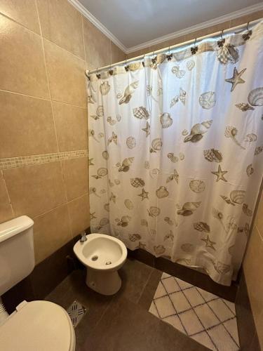 uma casa de banho com um WC e uma cortina de chuveiro em Chacabuco 8 em Tandil
