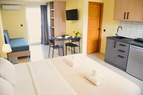 a room with a bed and a kitchen with a table at Eden Beach Hotel in Agia Marina Nea Kydonias