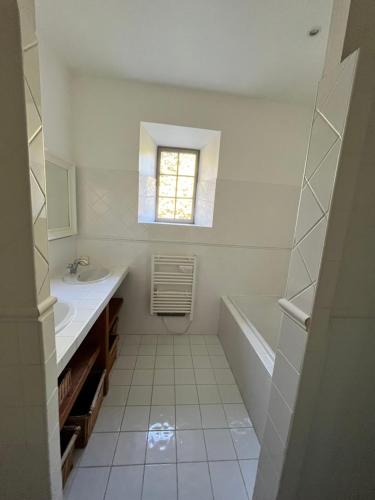 MontlaurにあるPavillon de Villefrancouのバスルーム(シンク、バスタブ付)、窓が備わります。