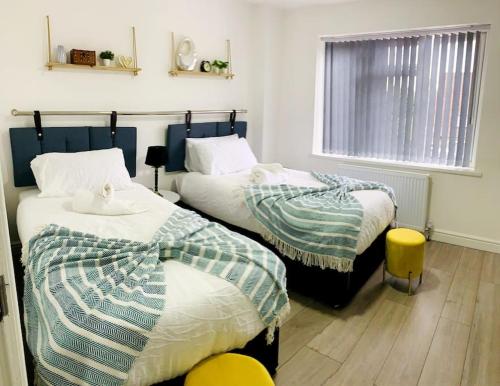 1 dormitorio con 2 camas y ventana en Large 7 Bedrooms split-level Flat Sleeps up to 14 en Birmingham