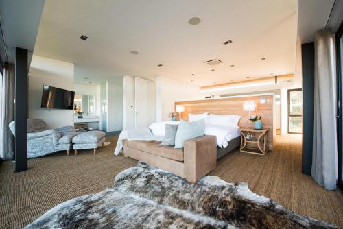 a bedroom with a large bed and a couch at Collection Luxury Accomodation Simola House in Knysna