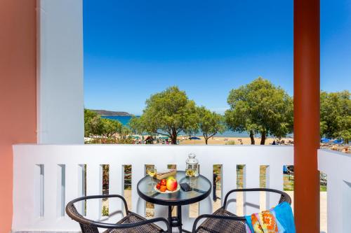 a table and chairs on a balcony with a view of the beach at Eden Beach Hotel in Agia Marina Nea Kydonias