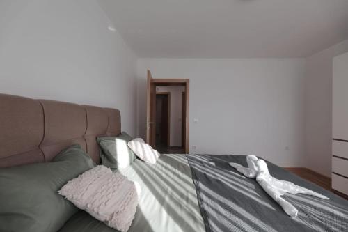a bed with two white towels on top of it at Apartmani Vinea Zara in Brčevec