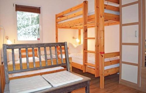 a bedroom with two bunk beds and a bench at Ferienhäuser Harzperle - Tanne in Tanne