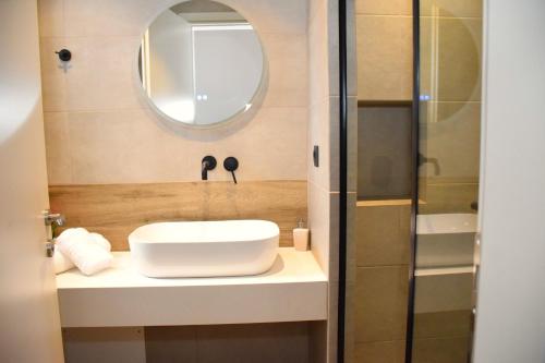 a bathroom with a sink and a mirror at Eden Beach Hotel in Agia Marina Nea Kydonias