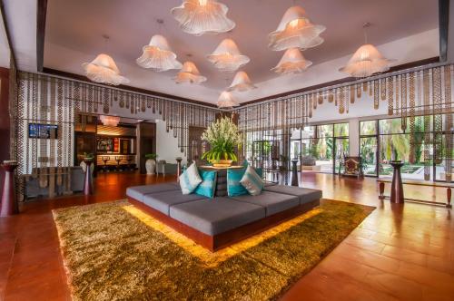 a large living room with a large couch on a rug at THE PRIVILEGE FLOOR by Lotus Blanc in Siem Reap