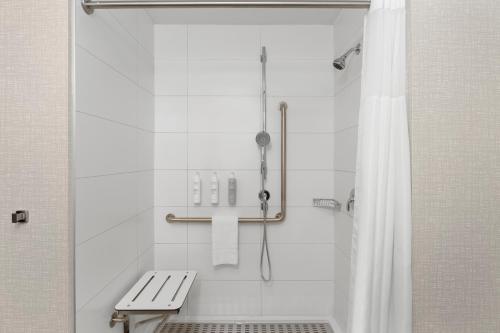 康沃爾的住宿－Hampton Inn By Hilton Cornwall，浴室设有带长凳和浴帘的淋浴