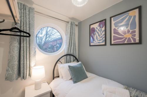 a small bedroom with a bed and a window at Walk to City Centre Townhouse, Garden and Parking by StayByNumbers in Belfast
