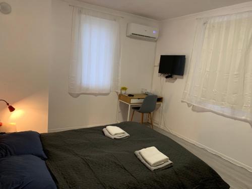 een slaapkamer met een bed met twee handdoeken erop bij Lipite Guest House 