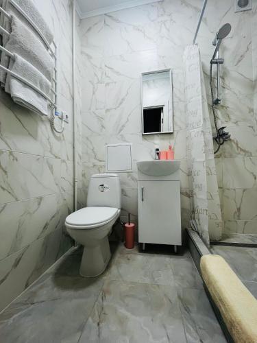 a white bathroom with a toilet and a sink at Апартаменти поряд дорослої і дитячої лікарні біля Миколайчука, Орлика in Lviv