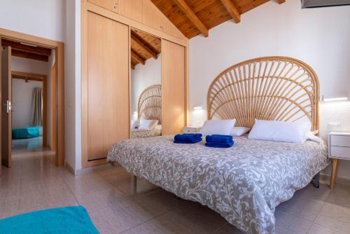 een slaapkamer met een groot bed met blauwe kussens erop bij Casa Lina HolidayFV in Corralejo