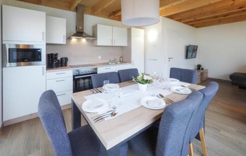 a kitchen with a wooden table and blue chairs at Lovely Home In Prümot Walcherath in Hermespand