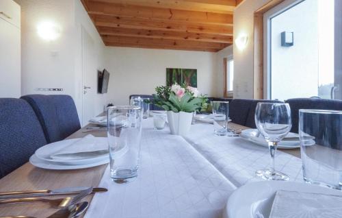 a table with glasses and plates and flowers on it at Lovely Home In Prümot Walcherath in Hermespand