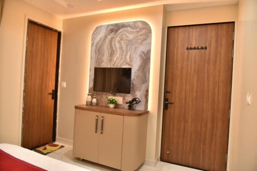 a room with a door and a tv on a wall at Hotel Shree Krishna in Jaipur