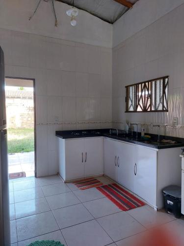 a white kitchen with a counter and a window at Start in Boa Vista