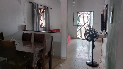 a dining room with a table and a floor fan at Start in Boa Vista