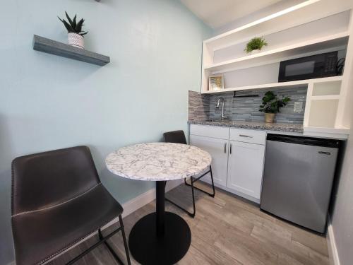 a small kitchen with a table and two chairs at Barefoot mailman motel in Lantana