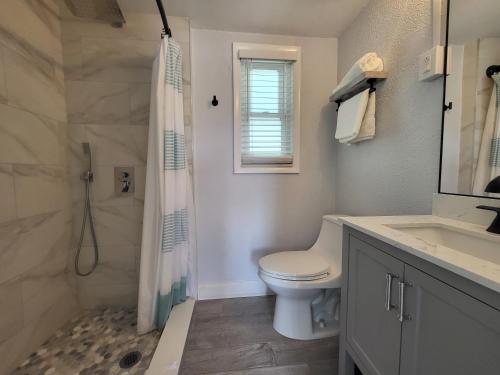 a bathroom with a toilet and a shower and a sink at Barefoot mailman motel in Lantana