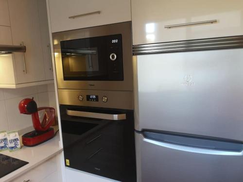 a kitchen with a microwave and a refrigerator at A Cabana I in Porriño