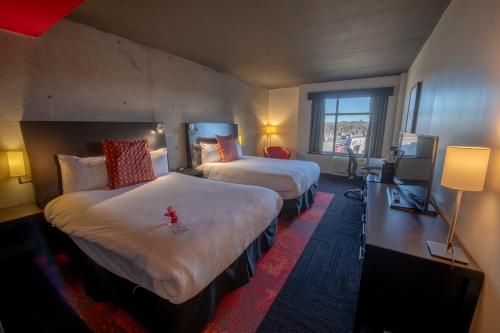 Grand Times Hotel – Aeroport de Quebec في مدينة كيبك: غرفة فندقية بسريرين ونافذة