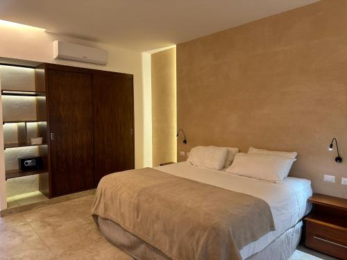 a bedroom with a large bed and a wall at Hotel Boutique Murana Tulum in Tulum