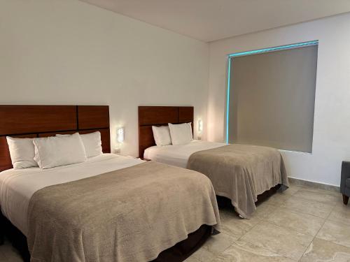 a hotel room with two beds and a window at Hotel Boutique Murana Tulum in Tulum