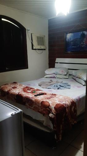 a bedroom with two beds and a tv on the wall at Pousada Suites Praia de Costazul in Rio das Ostras