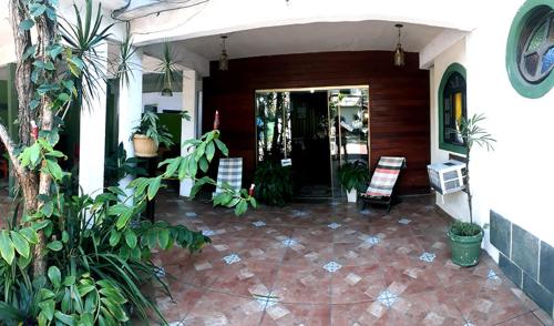 a porch of a house with chairs and plants at Pousada Suites Praia de Costazul in Rio das Ostras